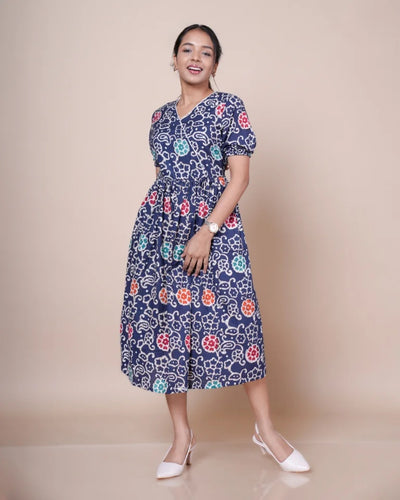 Elora Batik print cotton dress â€” model smiling in navy blue midi dress with multicolour floral print| Kaarigar